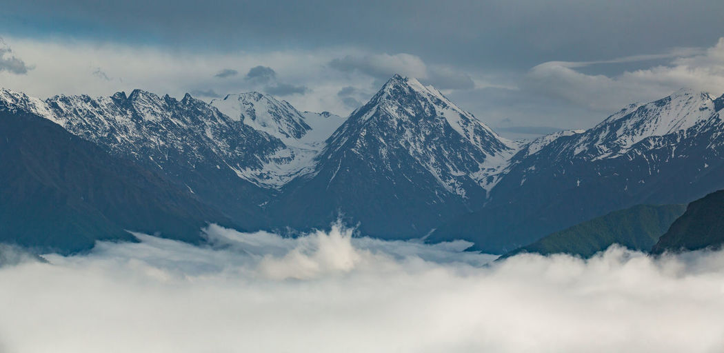 Mount tebulosmta in the clouds. scenic view of snowcapped mountains against sky