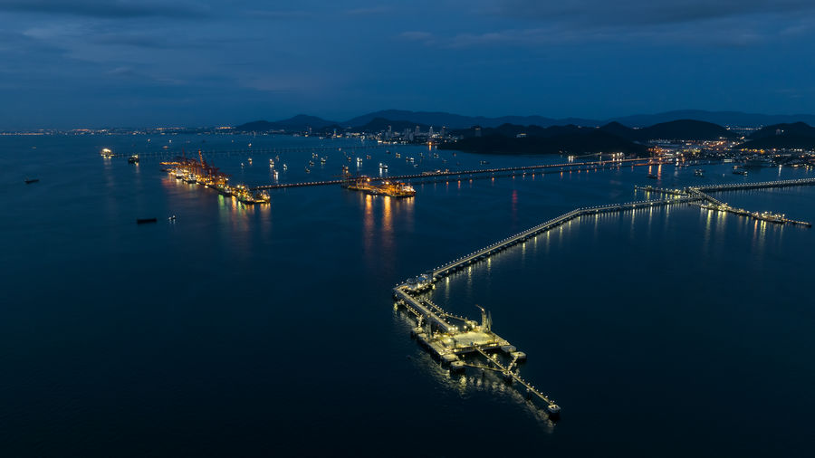 Aerial seascape view and oil and gas pipeline bridge stretched through the sea at twilight 