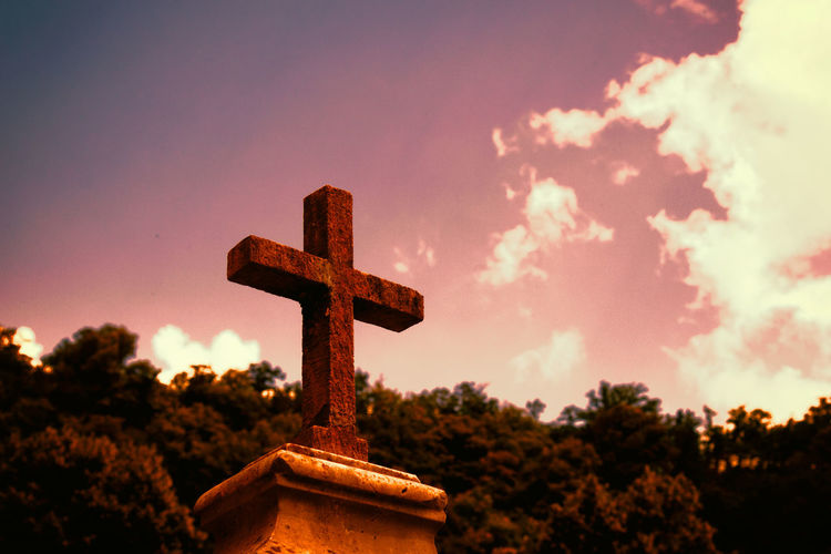 Close-up of cross in cemetery against sky