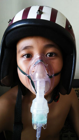 A boy playing like a fighting pilot with the helm and  inhalation equipment