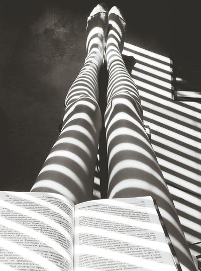 Shadow from blinds on woman's legs