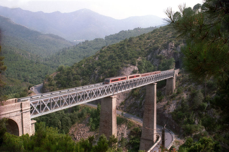 Passenger train at eiffel bridge in the mountains of corse island.