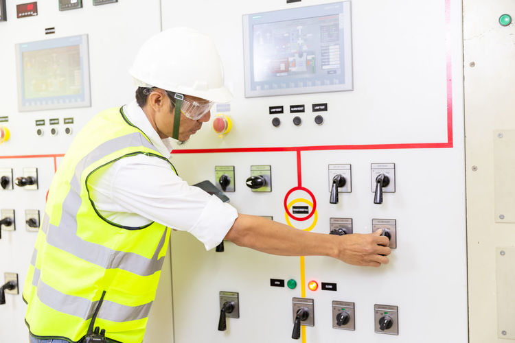 Maintenance engineers inspect relay protection system. bay control unit. medium voltage switchgear
