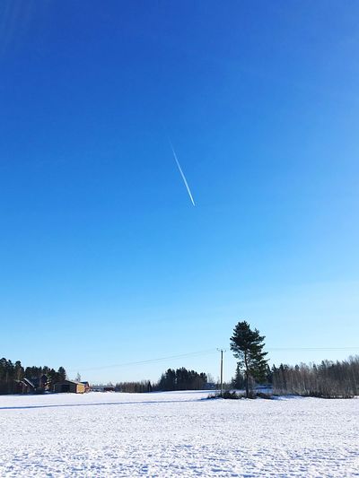 Scenic view of snowy field against clear blue sky