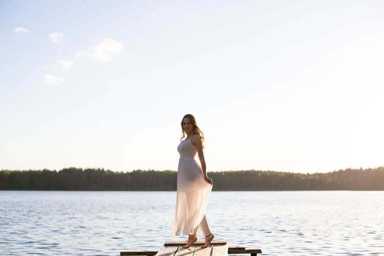 Rear view of woman sitting on lake