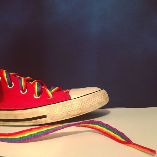 Rainbow shoe on table over blue background