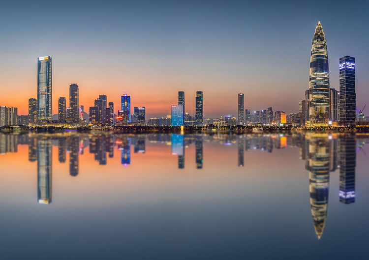 Illuminated buildings in city against sky