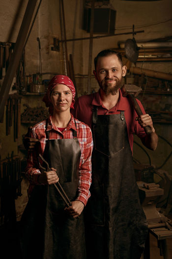 Portrait of blacksmiths standing in workshop