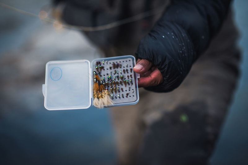 A man picks his flies during a cold morning fishing in maine