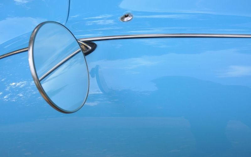 Close-up of cropped car against blue sky