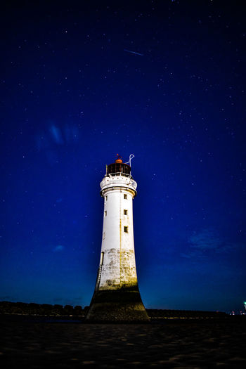 Lighthouse against sky at night