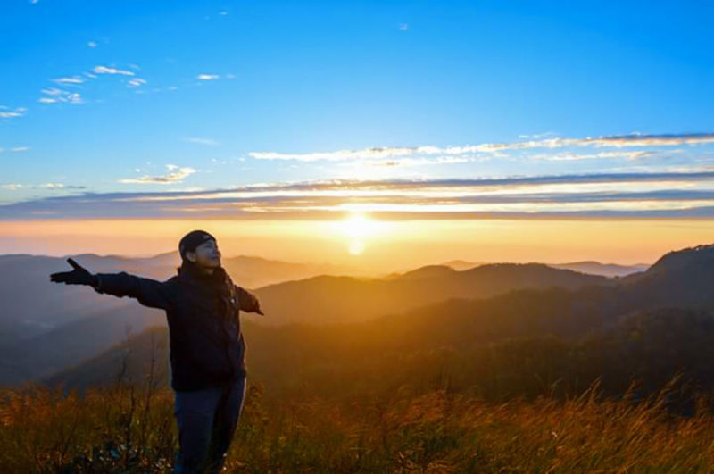 Full length of man standing on mountain during sunset