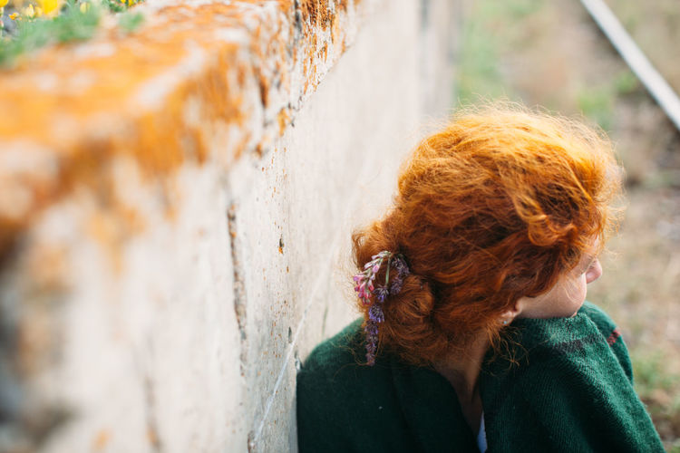 High angle view of woman standing against weathered wall
