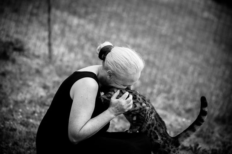 Senior woman playing with her cat in yard