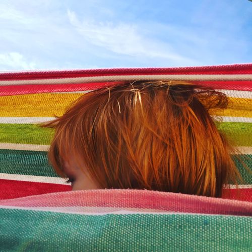Close-up of boy in hammock against sky
