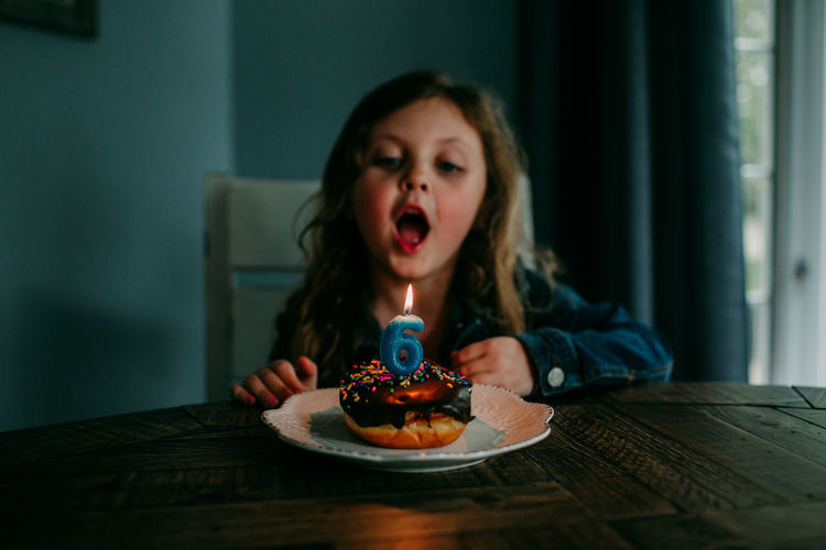 Cute girl blowing candle on birthday cake