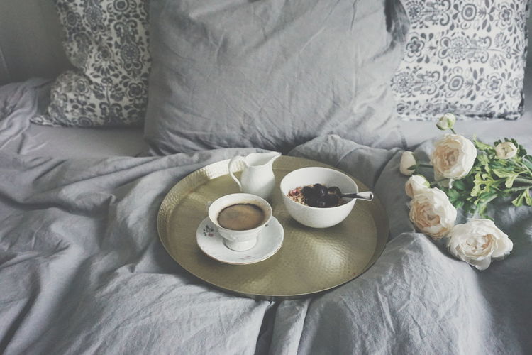 High angle view of coffee and food on bed