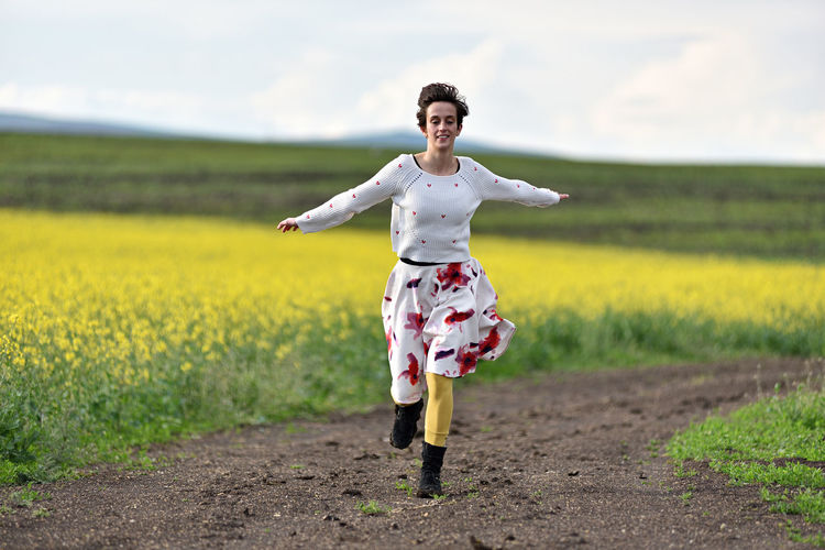 Cheerful woman running on a countryside road. freedom concept