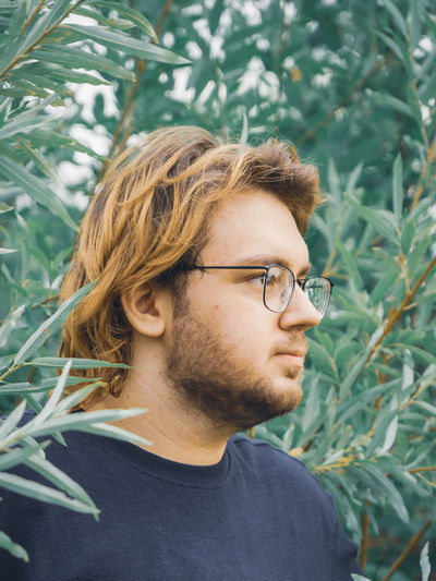 Portrait of a young man on a background of trees