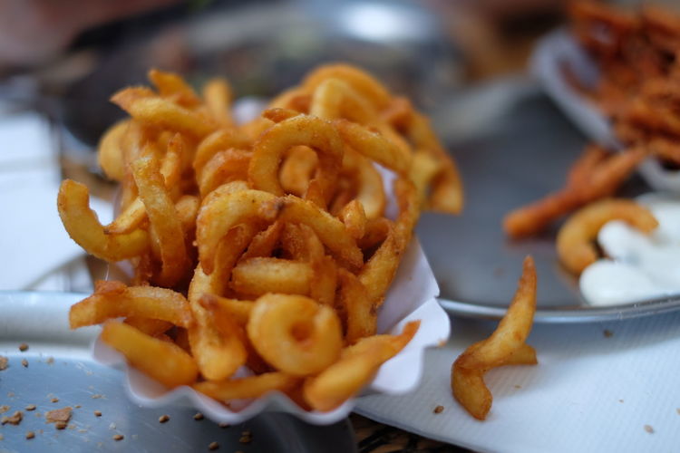 Close-up of onion rings and french fries in plate on table