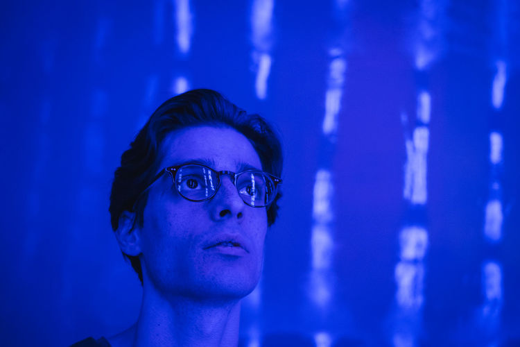 Close-up of thoughtful young man looking away at night