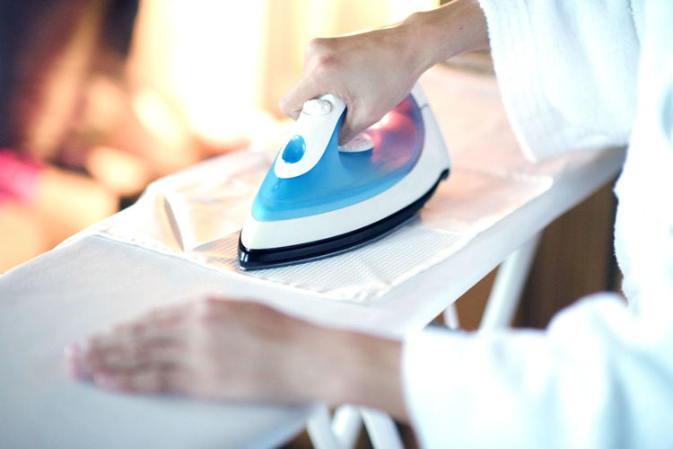 Midsection of woman ironing on table