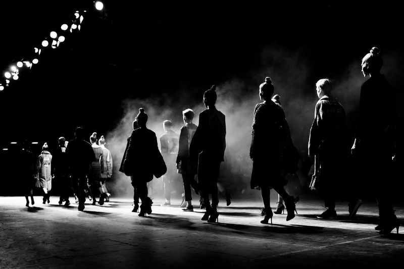 Rear view of models in row during fashion show