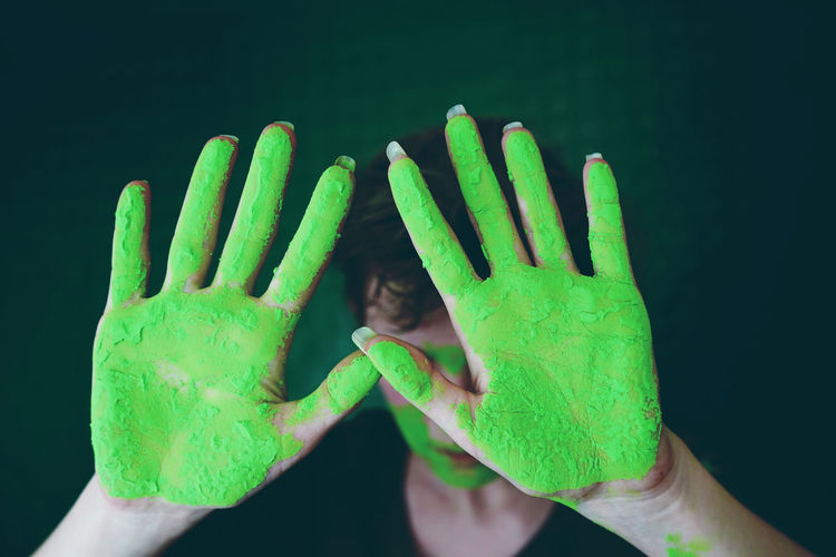 Close-up of woman gesturing with green hands