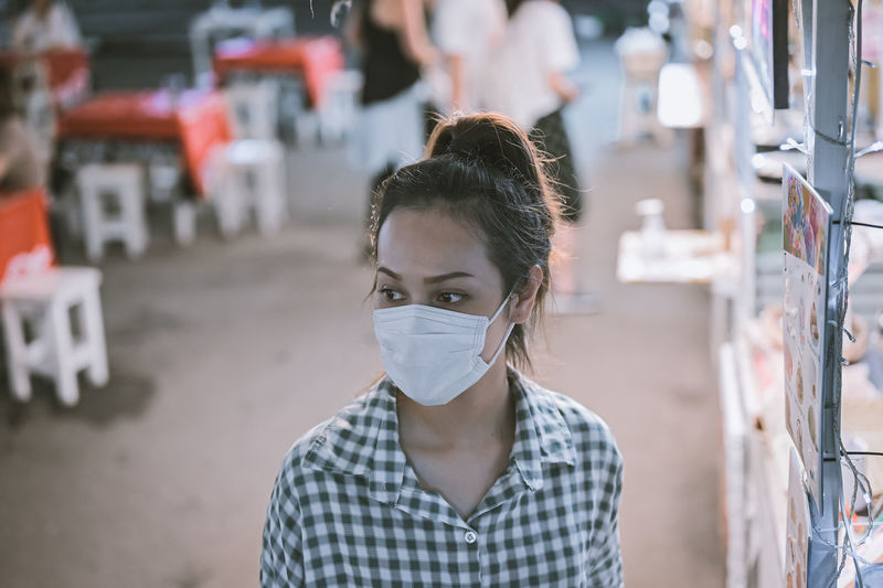 Series photo of young woman tourist wear surgical medical mask touring in street night market