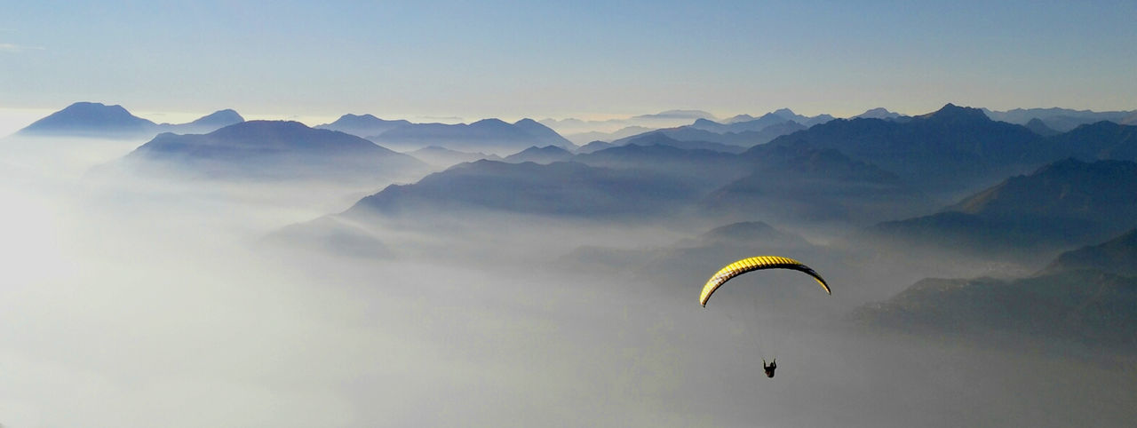 High angle view of person paragliding over mountains
