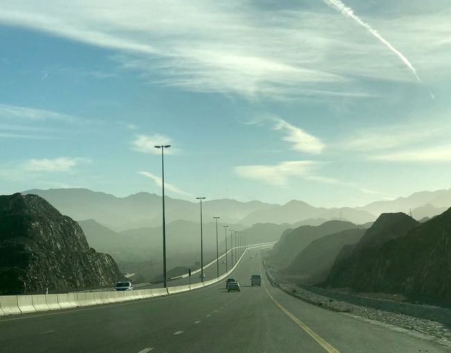 Road by mountain against sky