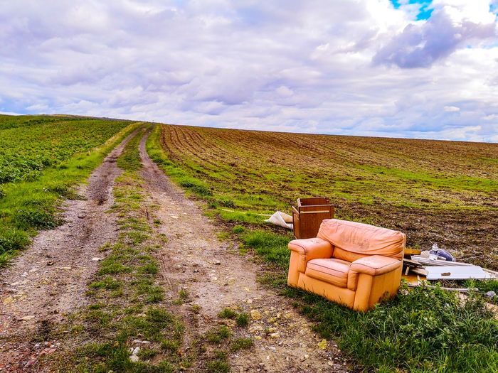 Scenic view of agricultural field against sky with an armchair in the foreground