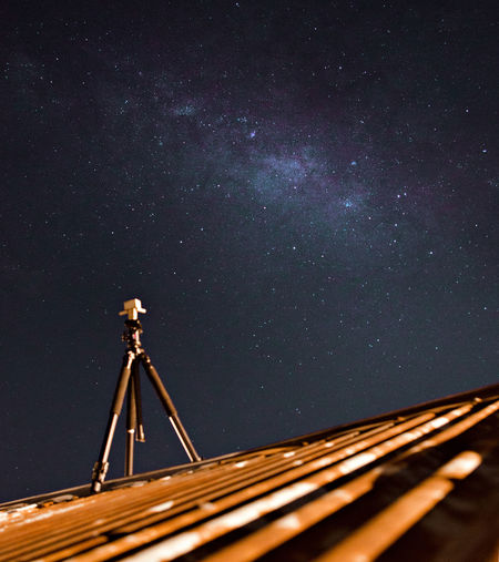 Telescope on roof against star field