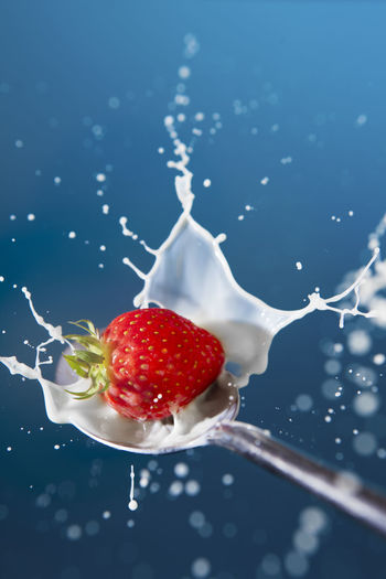 Close-up of strawberries on glass against white background
