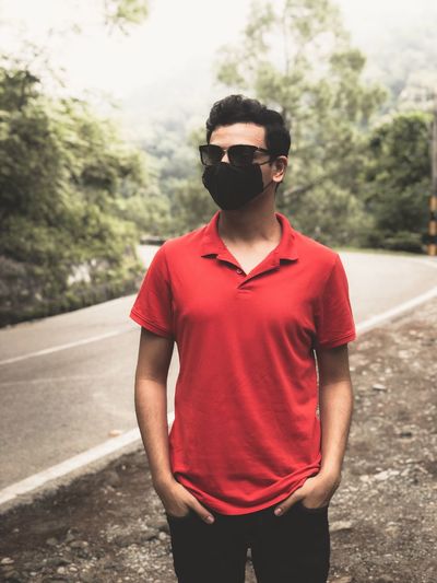 Young man wearing sunglasses standing on road