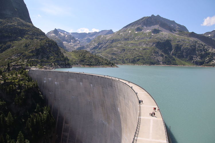 Scenic view of dam and mountains against sky