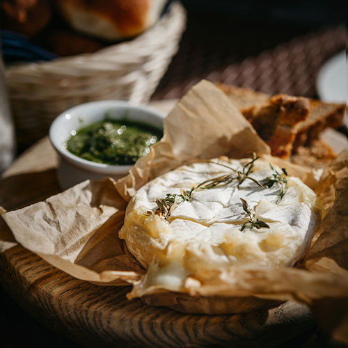 Oven baked camembert cheese with rosemary and pesto sauce