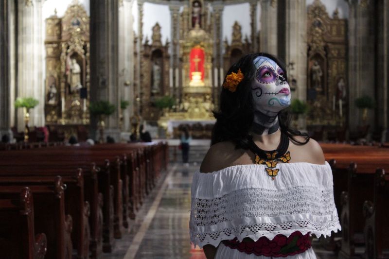 Young woman with painted face standing in church