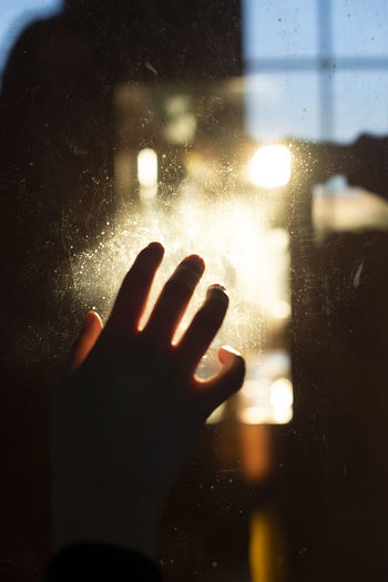 Close-up of person hand on glass window