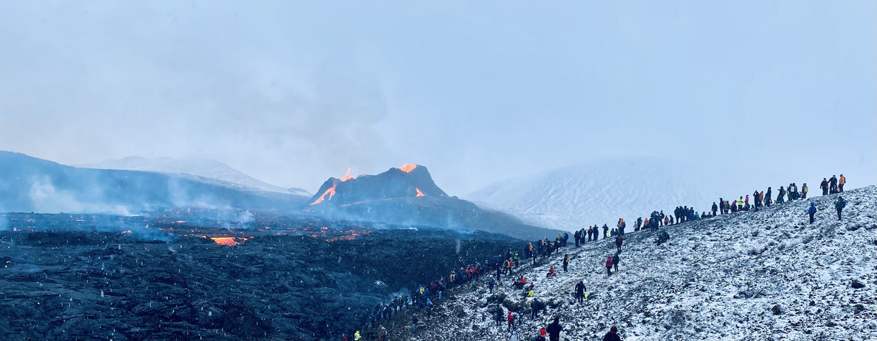 Panoramic view of crowd on mountain against sky