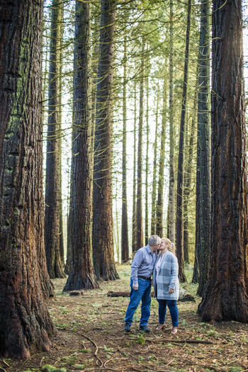 Romantic retired couple kissing in the forest.