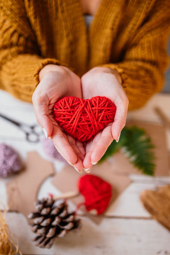 High angle view of woman holding heart shape on table