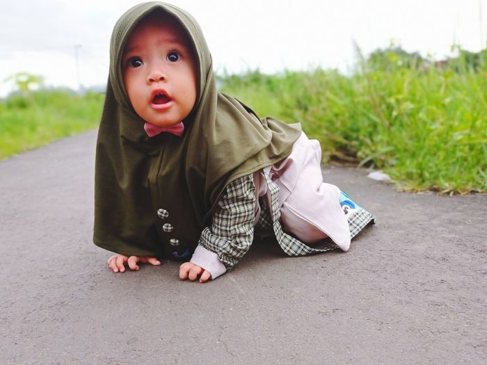 Portrait of young woman sitting on road