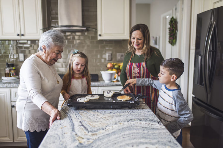 Multigenerational family making breakfast in the kitchen