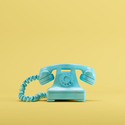 Close-up of telephone against yellow background