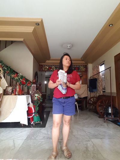 Full length portrait of woman standing on floor at home