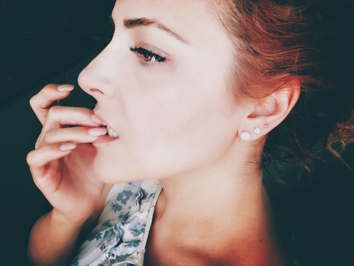Close-up of woman biting nail