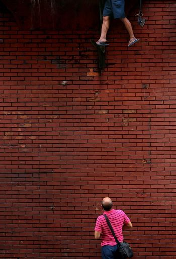 Person standing against brick wall