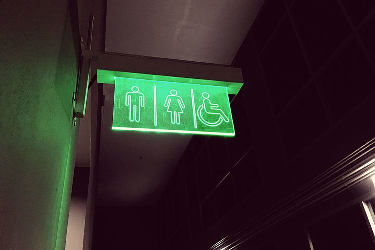 Low angle view of green restroom sign