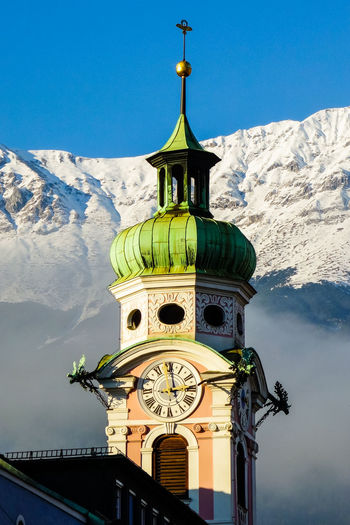 Low angle view of clock tower against sky during winter